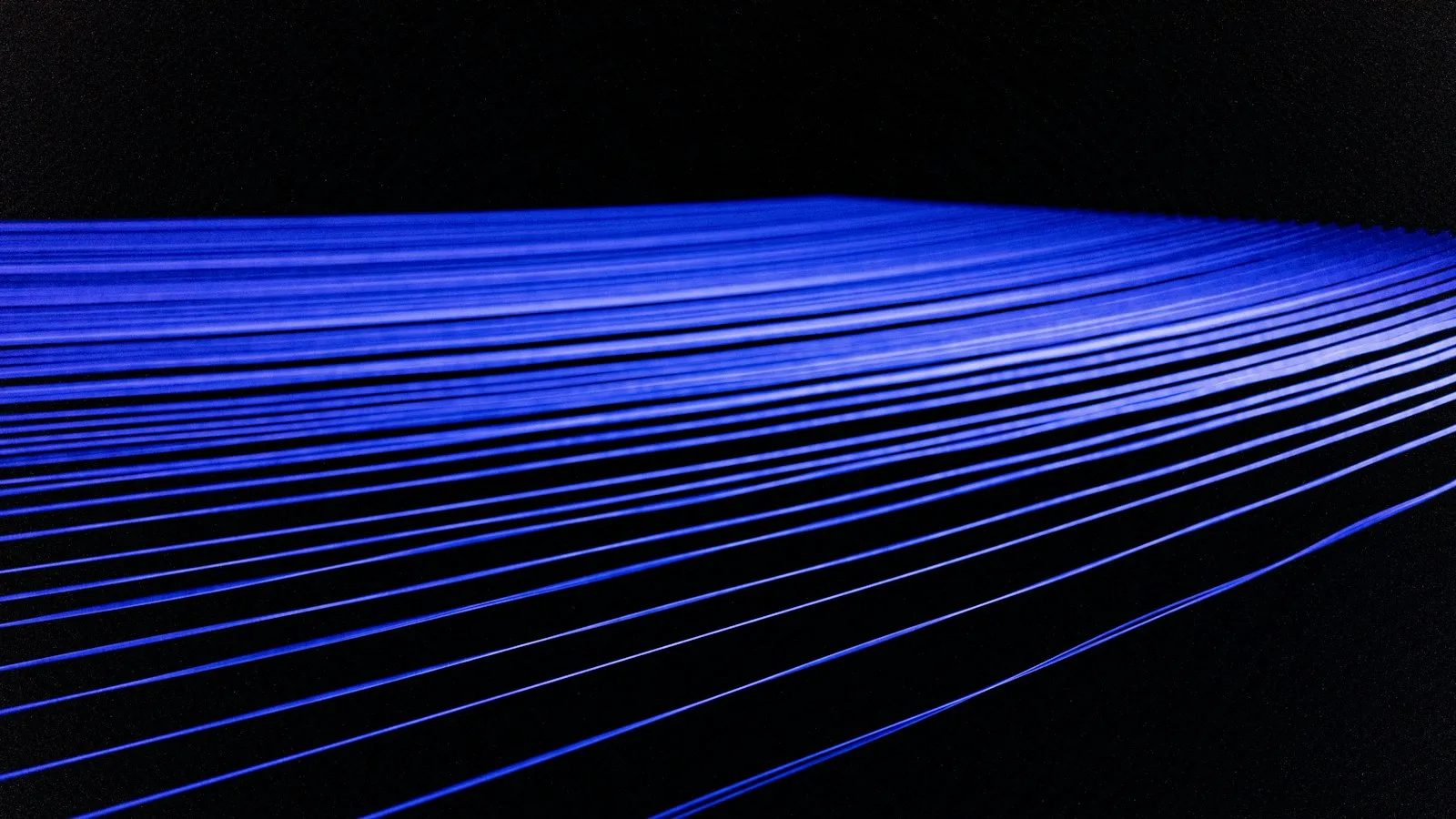 Fines bandes de lumière bleue au centre d’un fond noir, dans une composition minimaliste